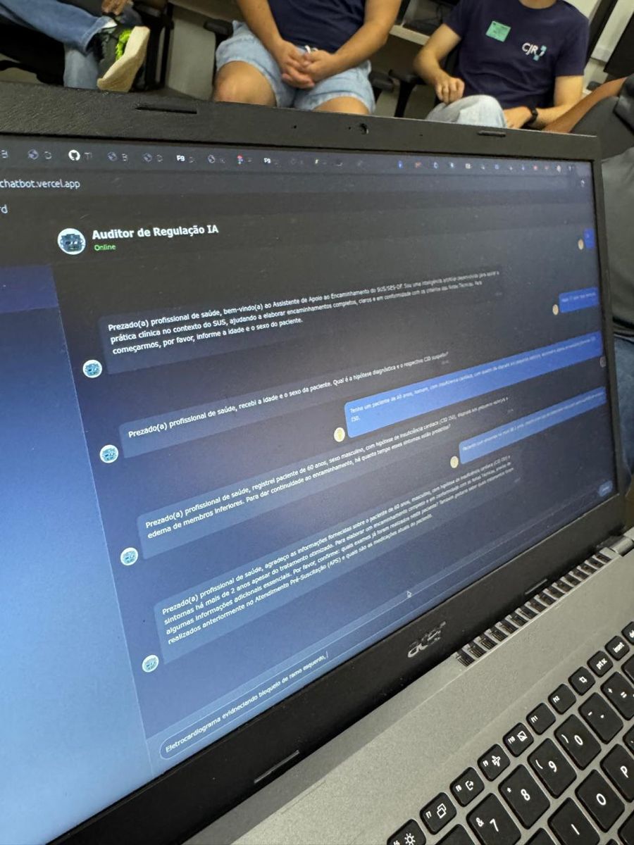 Notebook mostrando o chatbot em uso, com uma conversa sobre um caso fictício, durante a oficina no Conecta HUB.